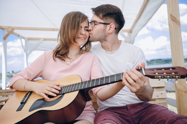 Girl getting a kiss while playing the guitar