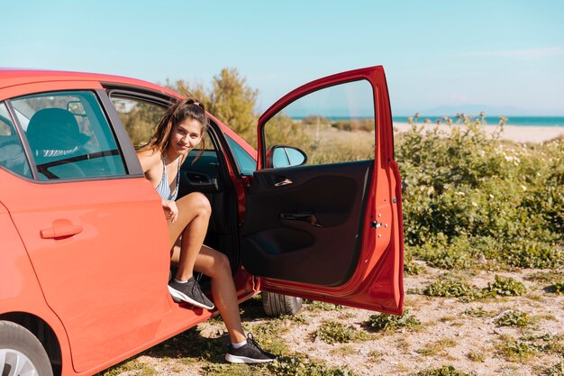 Girl getting out of car and looking at camera 