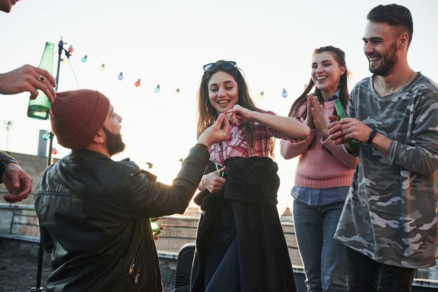 Girl gives her pinky finger. Declaration of love on the rooftop with company of friends