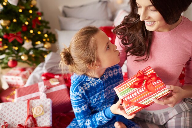 彼女のお母さんにクリスマスプレゼントを与える女の子