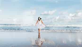 Free photo girl going out of the sea wearing white clothes