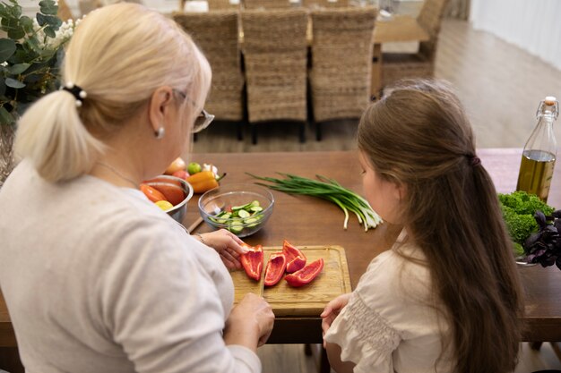 Girl and grandma cooking together medium shot