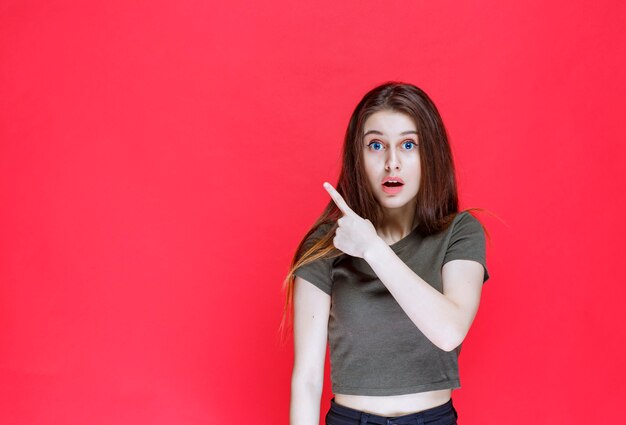 Girl in green shirt showing something on the west. 