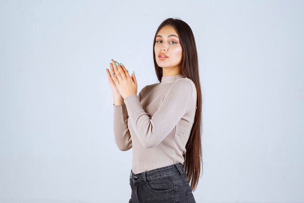 Girl in grey shirt applauding something. 