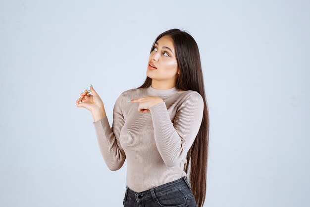 Girl in grey shirt looks excited and surprized. 