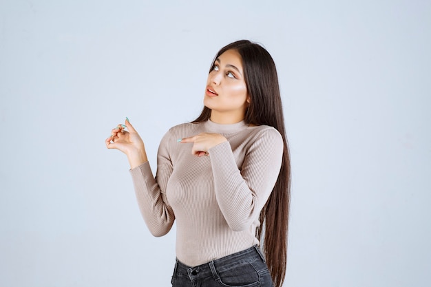 Girl in grey shirt looks excited and surprized. 