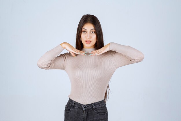 Girl in grey shirt looks surprized and confused. 