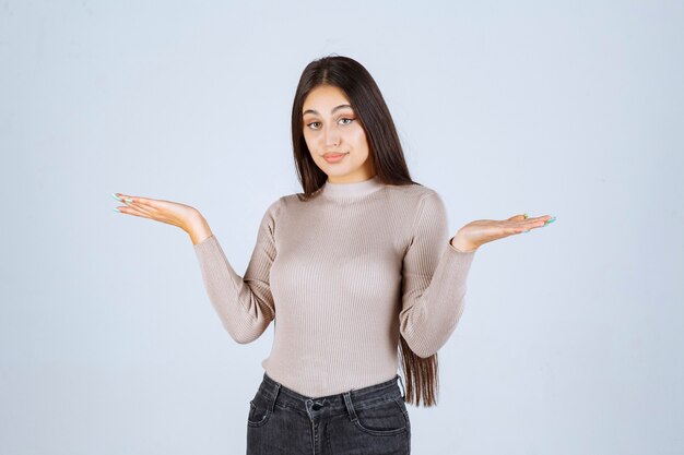 Girl in grey shirt looks surprized and confused. 