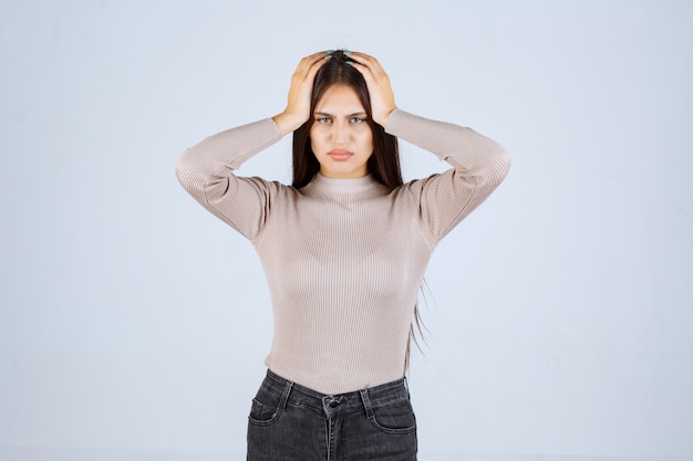 Girl in grey shirt looks surprized and confused. 