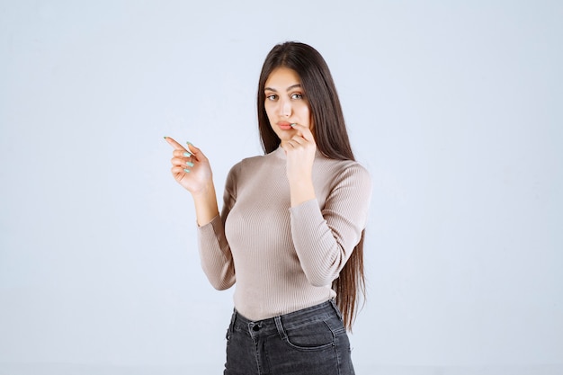 Girl in grey shirt looks surprized and confused. 