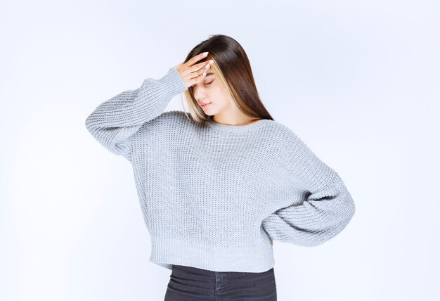 Girl in a grey shirt looks terrified and scared.