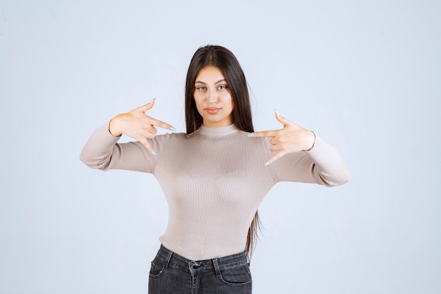 Girl in grey shirt making call sign. 