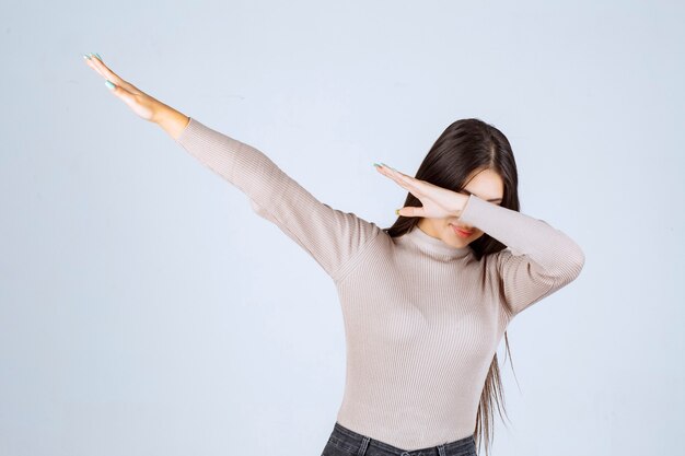 Girl in grey shirt raising her hands up. 