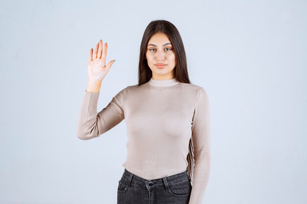 Girl in grey shirt raising her hands up. 