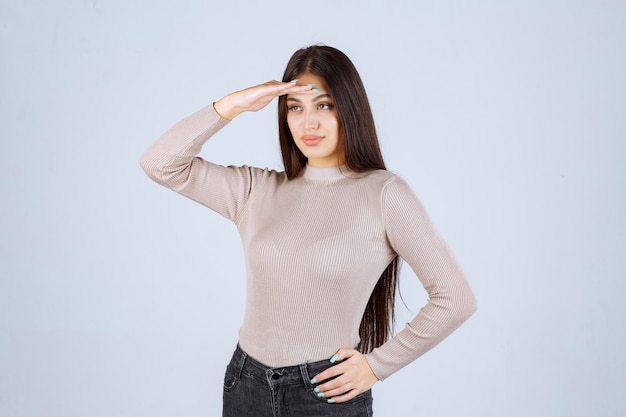 Girl in grey shirt saluting like a soldier. 