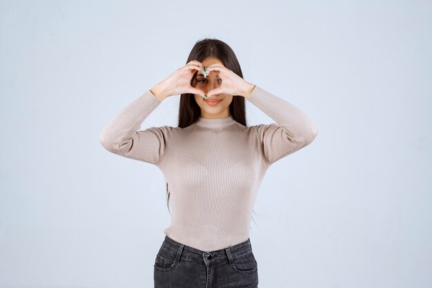 Girl in grey shirt sending love to her fans. 