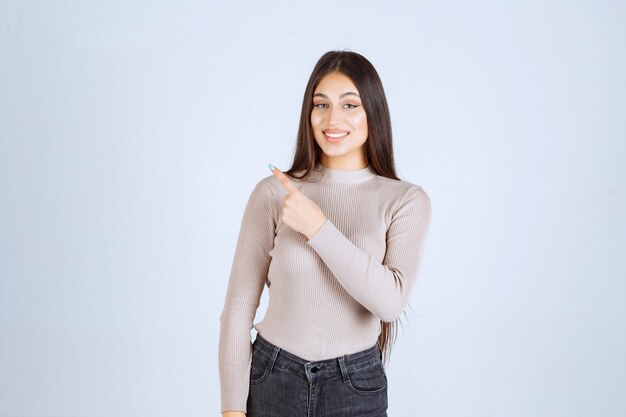 Girl in grey shirt showing something above and getting excited.