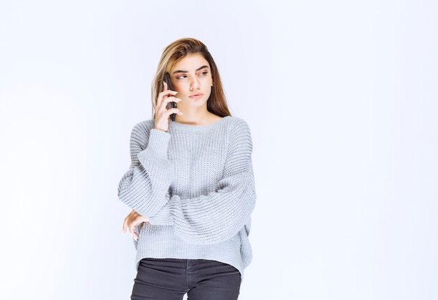 Girl in grey shirt talking to the phone.