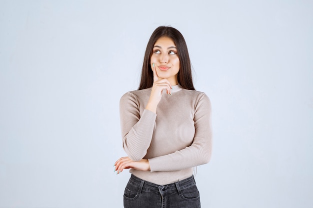 Foto gratuita ragazza in maglione grigio che dà pose cattive e seducenti.