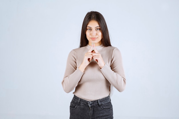 Ragazza in maglione grigio che dà pose cattive e seducenti.