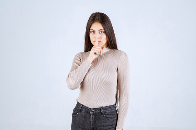 Girl in grey sweater pointing something above. 