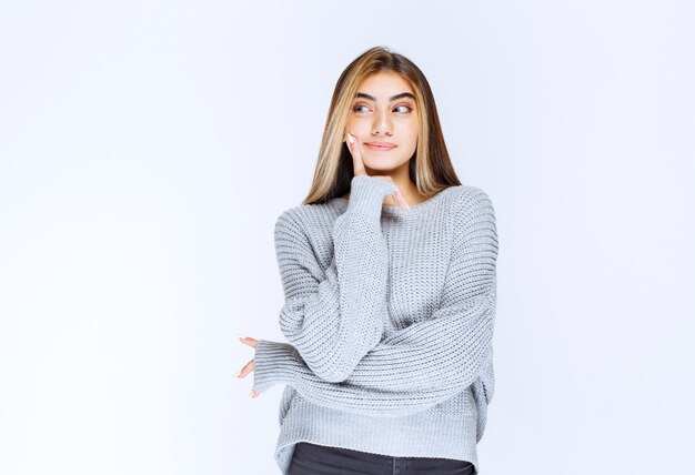 Girl in grey sweatshirt thinking and analyzing. High quality photo