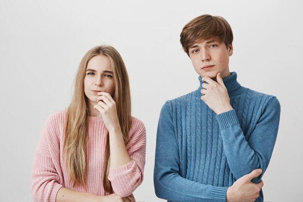 Девушка и парень стоят вместе, думая, делая выбор