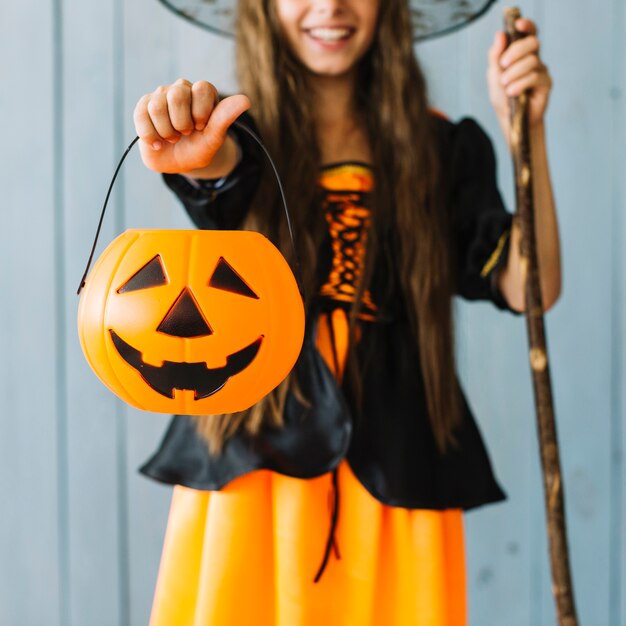 Girl in Halloween costume holding basket in hand