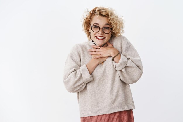 Girl happy and thankful grinning from sweet tender gift holding hands on chest in grateful and pleased pose