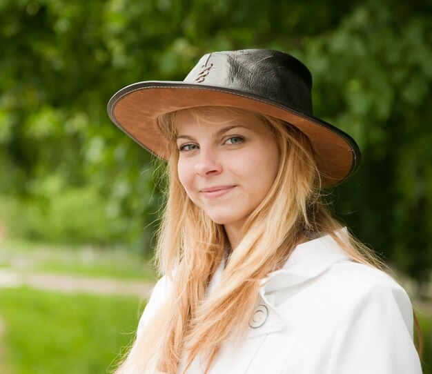 Девушка в шляпе против парка