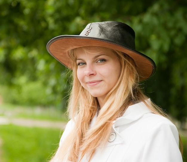 girl in hat against park