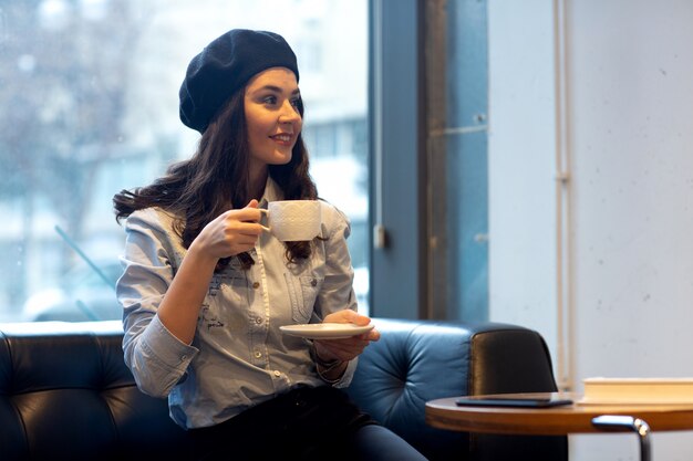 Girl in hat drinks coffee