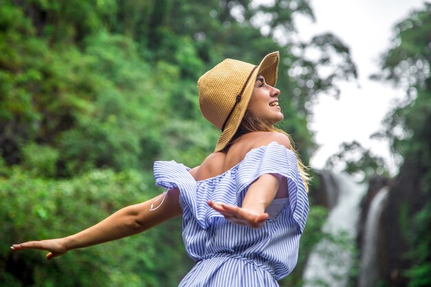 girl in hat looking at the waterfall