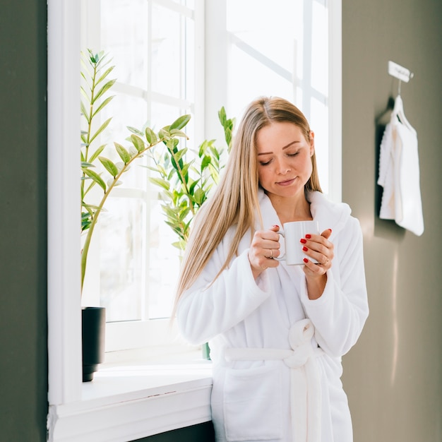 Free photo girl having coffee at the bathroom