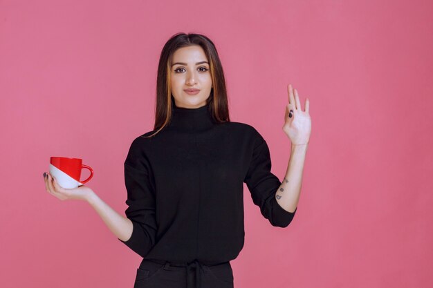 Girl having a cup of coffee and enjoying the taste. 