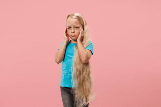 Girl having headache. Isolated over pink