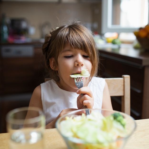 自宅で健康的な食事を持つ少女