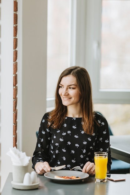 Foto gratuita ragazza con un succo d'arancia in un ristorante