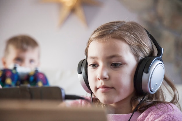 Free photo girl in headphones browsing tablet