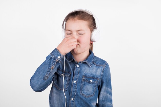 Girl in headphones covering nose