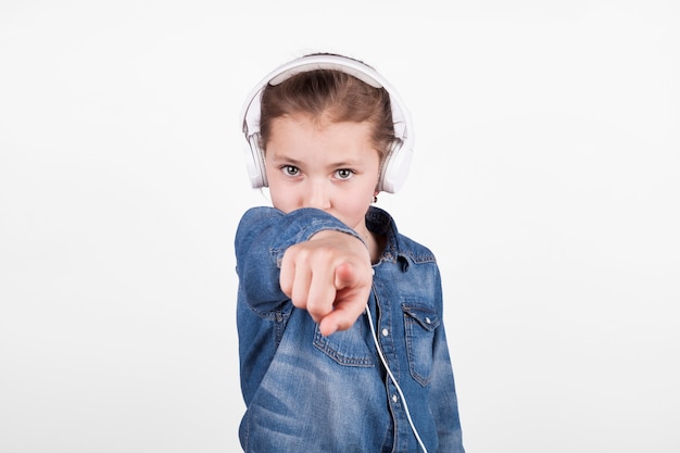 Girl in headphones pointing at camera