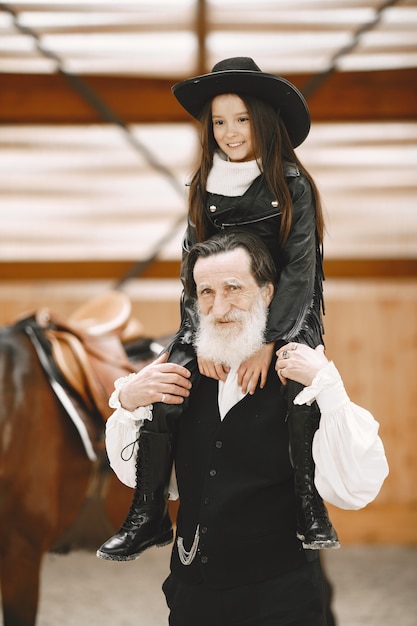 Girl in helmet Learning Horseback Riding. Instructor teaches little girl.