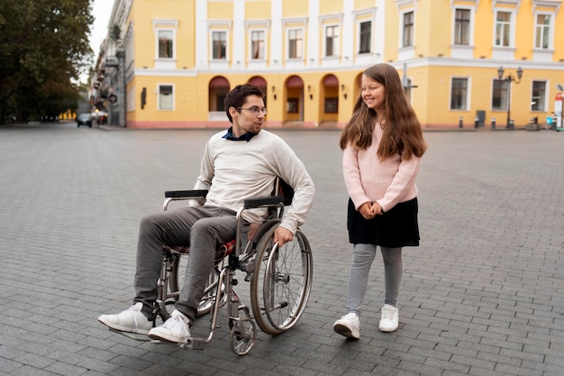 市内を旅行する障害者の男性を助ける女の子