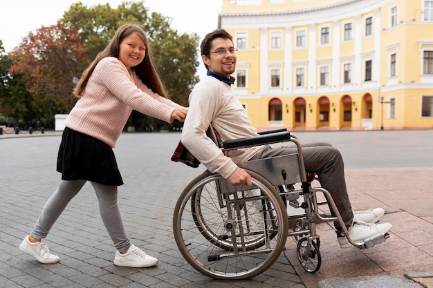 Girl helping disabled man traveling in the city