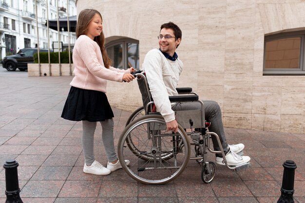 Девушка помогает инвалиду путешествовать по городу