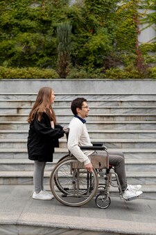 Girl helping disabled man traveling in the city