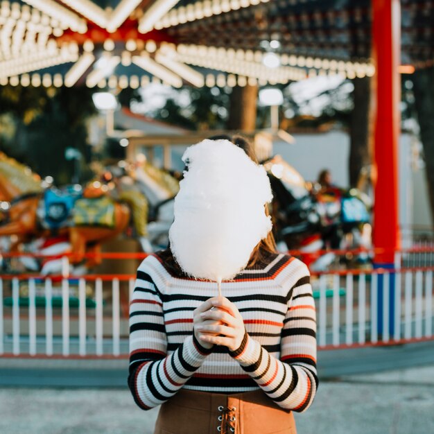 Girl hiding behind cotton candy