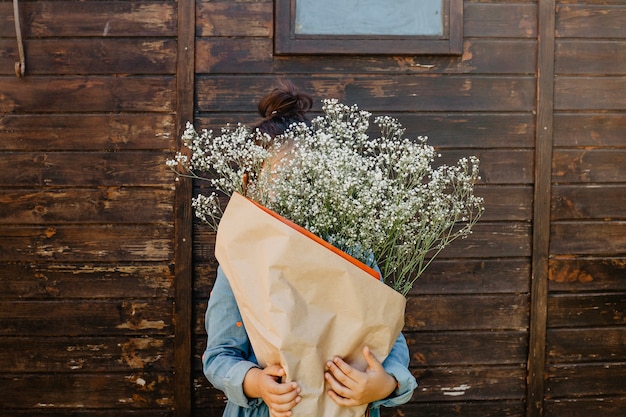 Girl hiding face behind bouquet