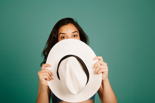 Girl hiding behind hat