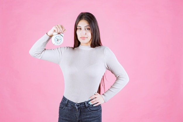 Girl holding an alarm clock and promoting it